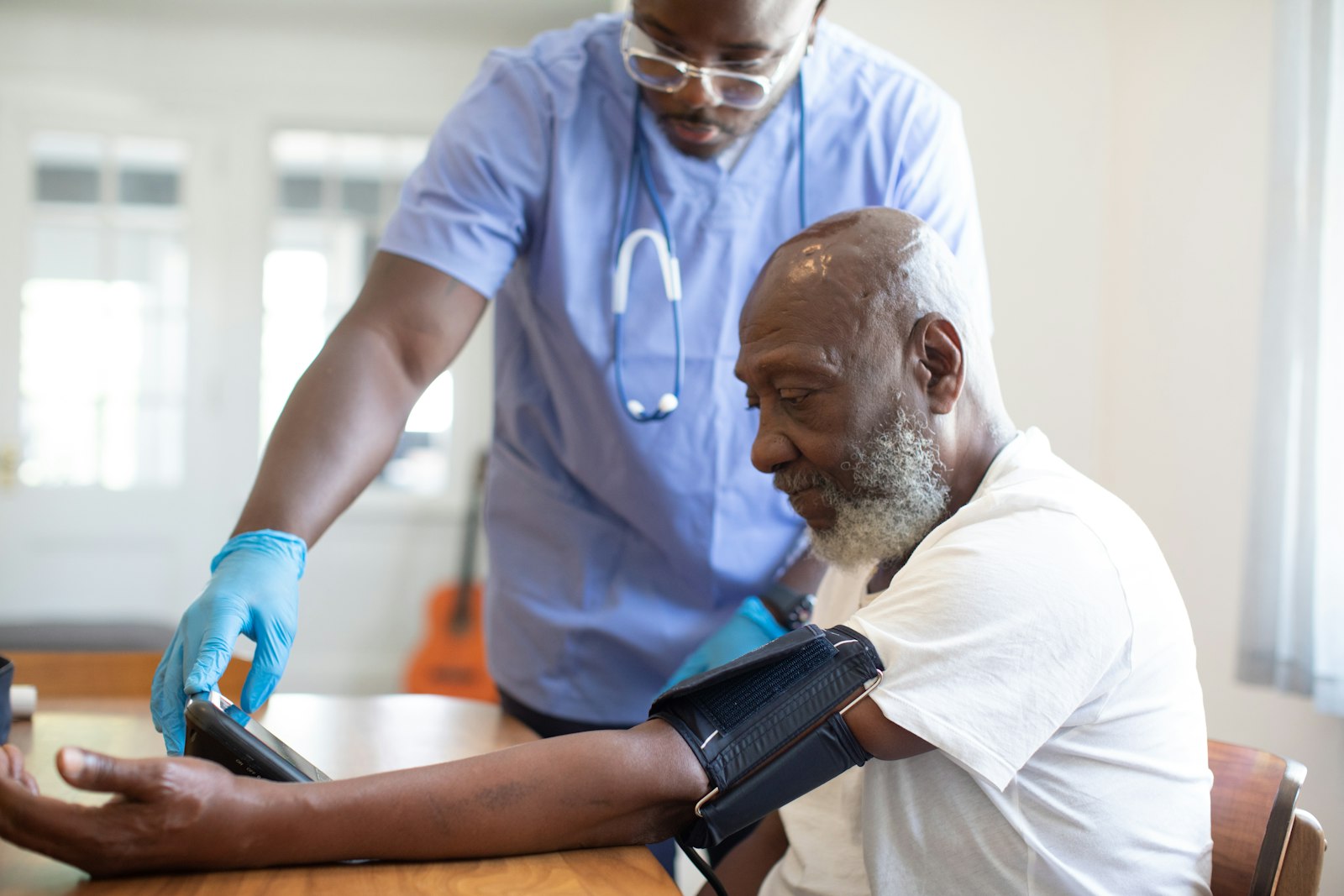 A nurse checking a senior client's blood pressure at home