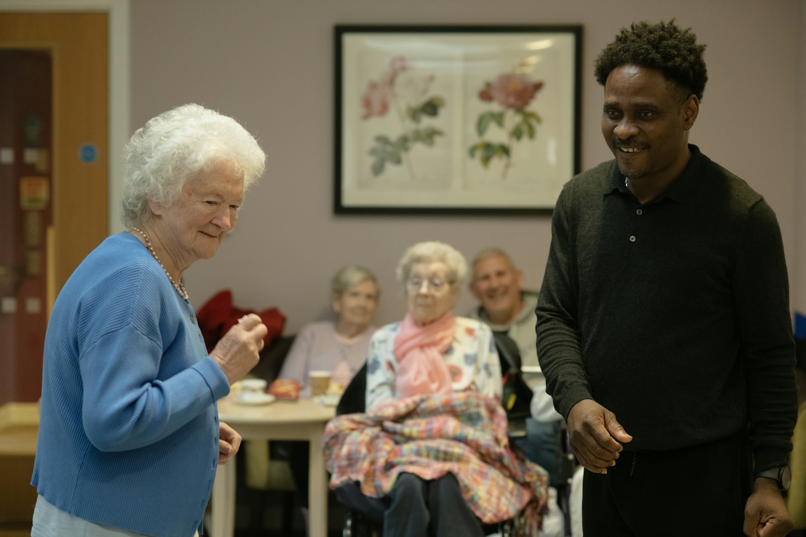 A caregiver spending time with clients in a comfortable home common room
